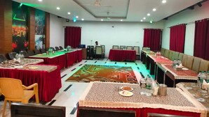 Une salle de conférence équipée de plusieurs tables, de chaises et d’une estrade.