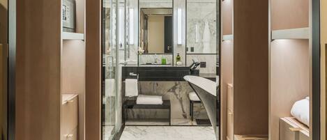 A modern bathroom with a marble floor, a sink with a mirror, and built-in shelves.