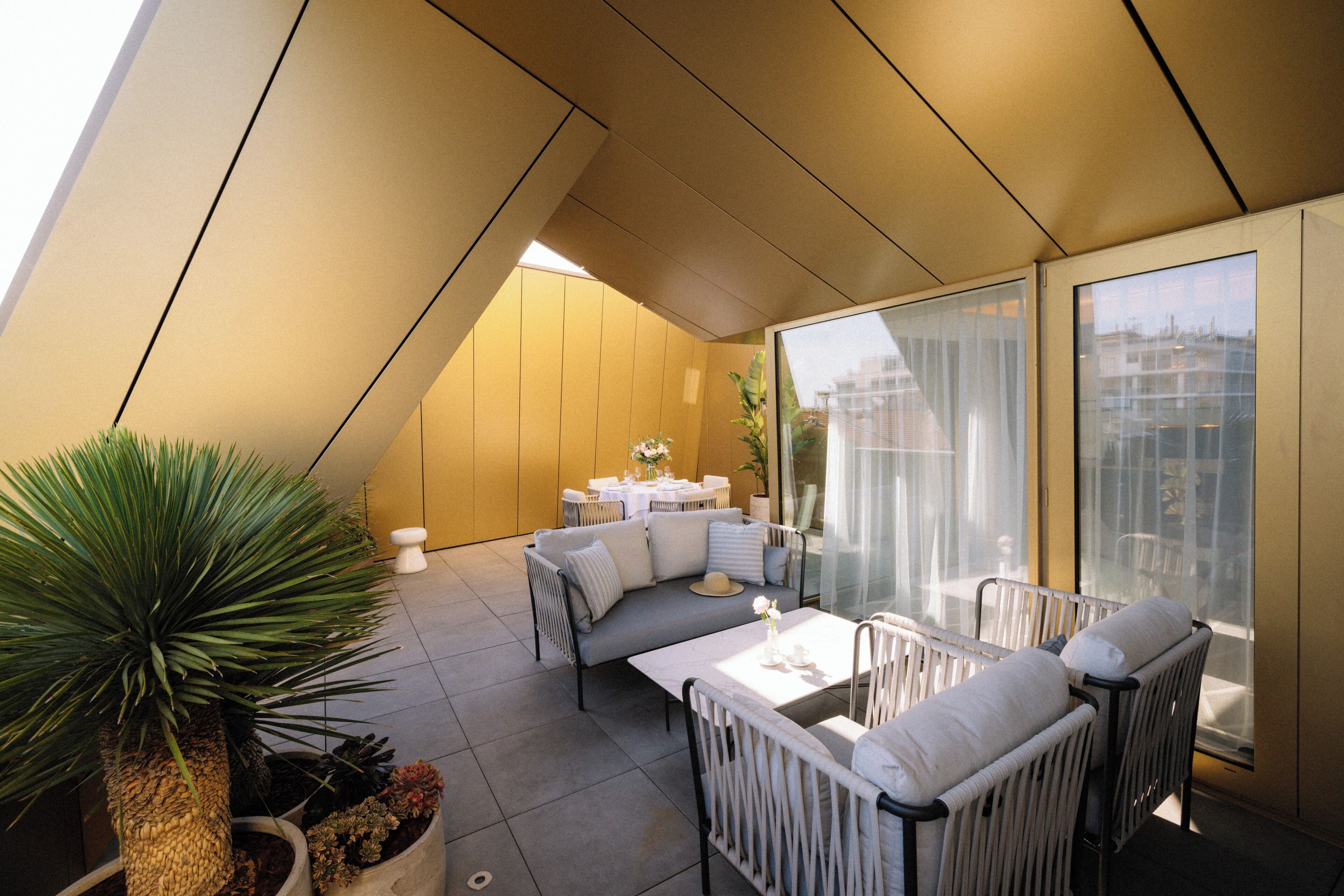 A modern interior with a dining area, seating, and a large window.