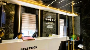 Un comptoir d’accueil avec une horloge et un panneau indiquant l’heure limite pour quitter les lieux.