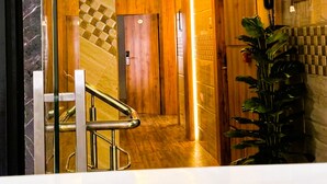 Un hall d’hôtel avec un escalier, un comptoir d’accueil et une plante.