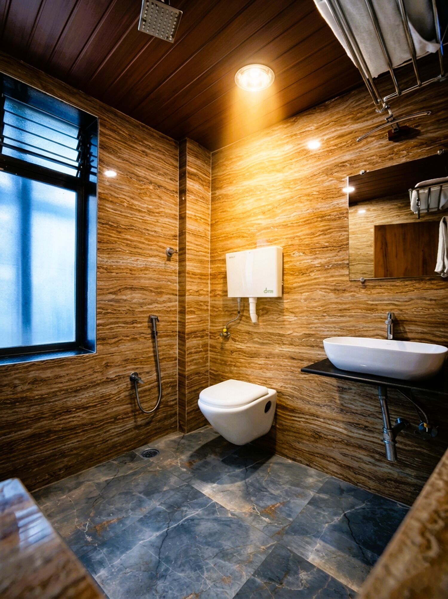 Een moderne badkamer met een marmeren vloer, een wit toilet, een wastafel met spiegel en een douche.