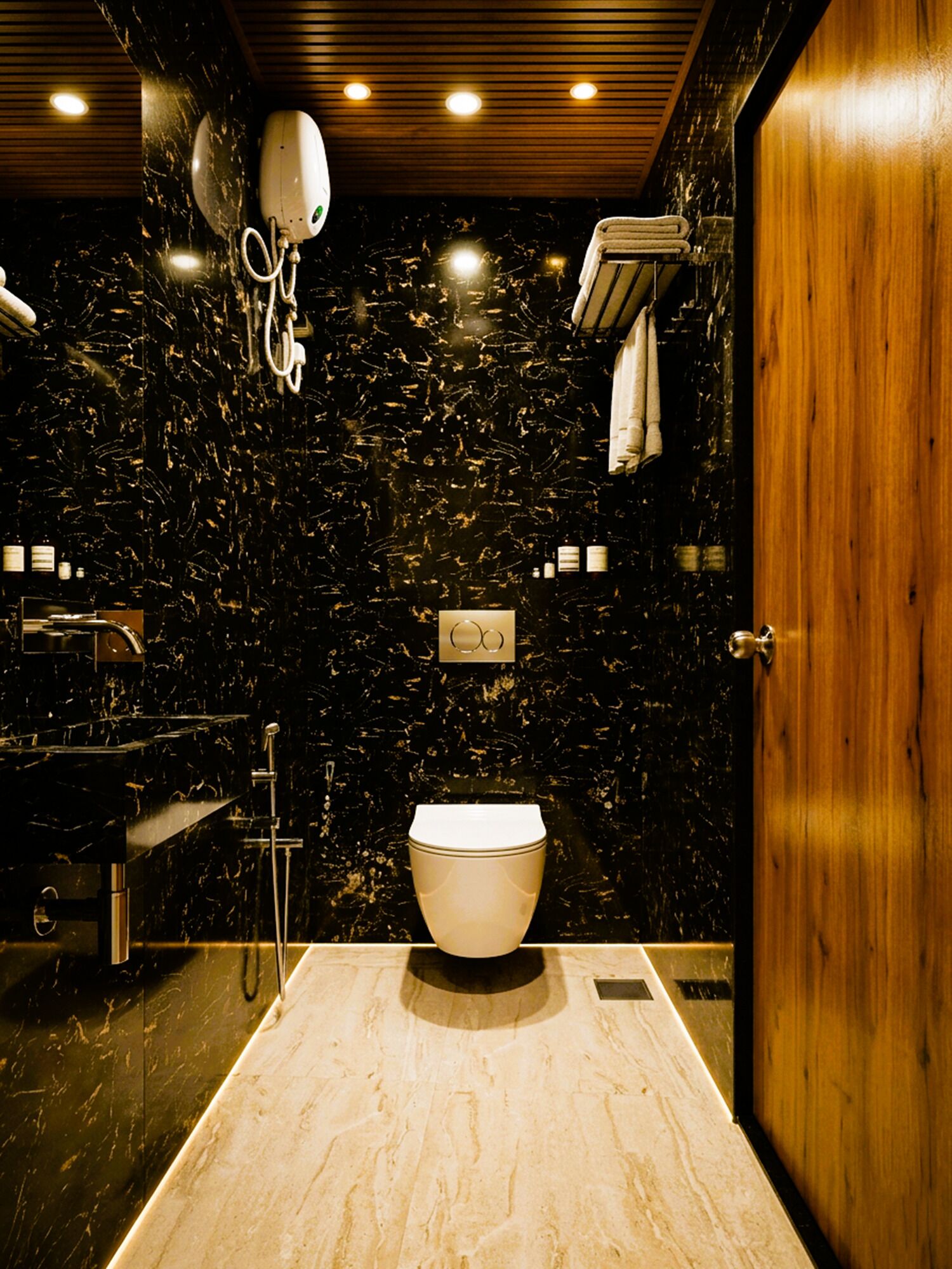 A modern bathroom with a marble wall, a white toilet, a sink, and a towel rack.