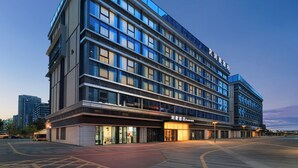 A multi-story hotel with a modern design, featuring large windows and a prominent signage. - RunhaoHOTEL (Chengdu)