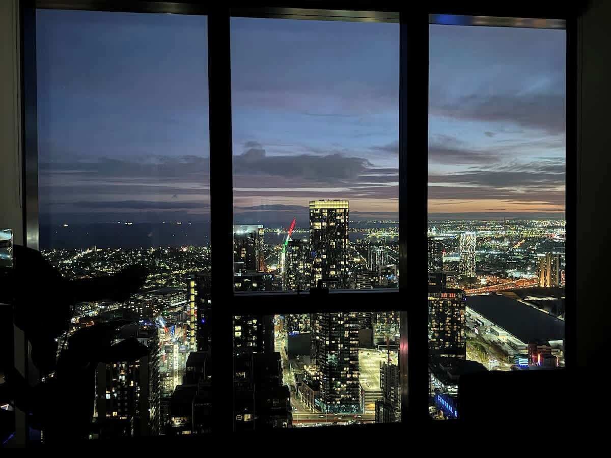 A cityscape view from a high-rise window at night.