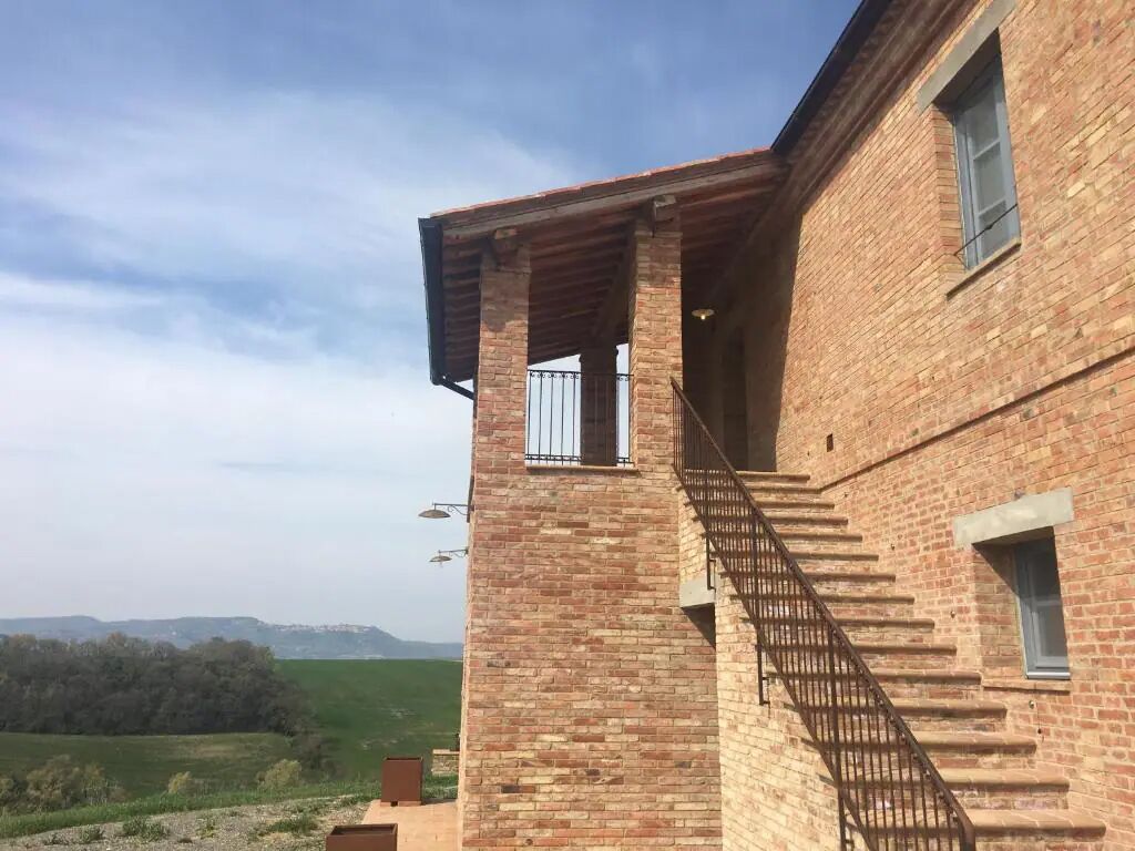 A brick building with a staircase leading to a balcony.