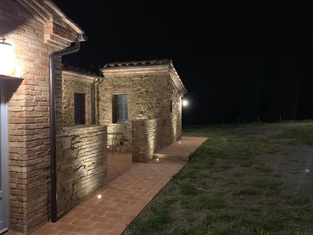 Un edificio de piedra con un sendero de ladrillo que conduce a una puerta.