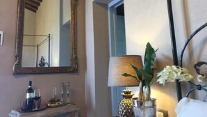 A room with a large ornate mirror, a lamp, and a vase with flowers. - Cordella in Valdorcia Truffle & Olive Oil Resort - Podere Borgasso (Montalcino)