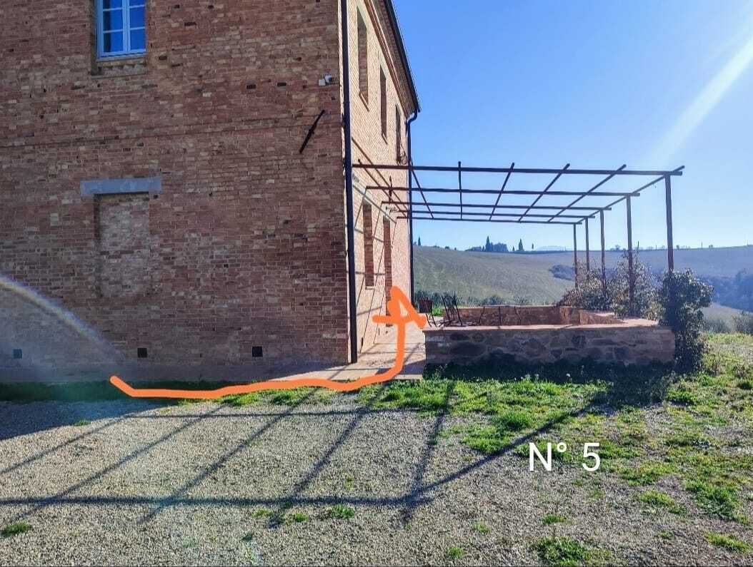 Ein Backsteinhaus mit einer Pergola.