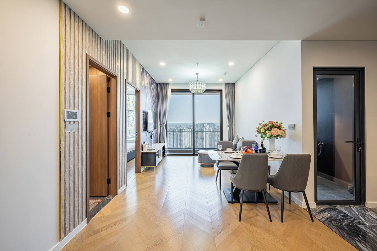 Ein modernes Wohnzimmer mit Essbereich, großen Fenstern und Blick auf die Stadt.