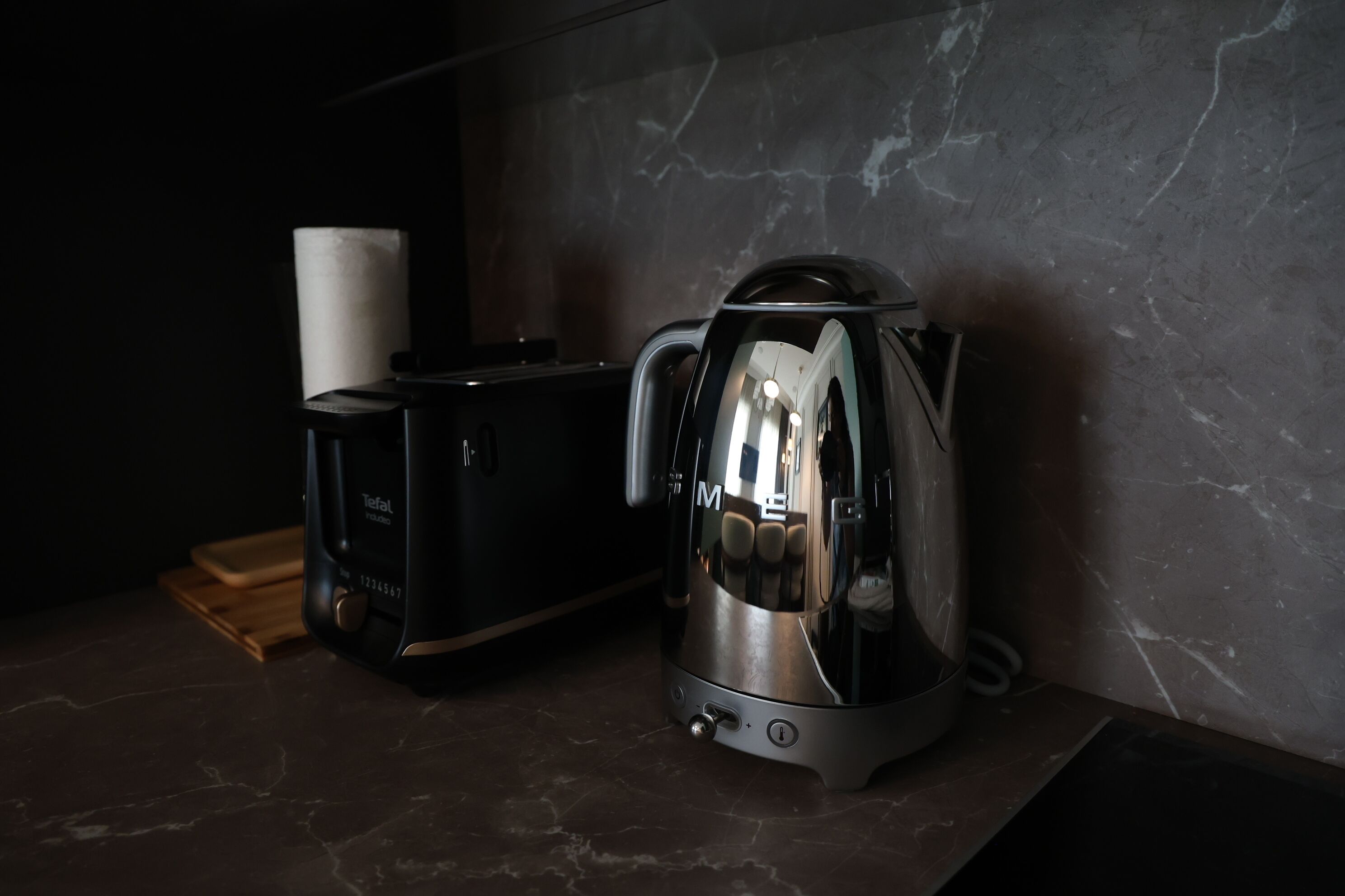 A kitchen with a toaster and a coffee maker on a marble countertop.