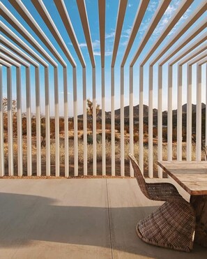 Relax in a serene outdoor space with a wooden table and two chairs.