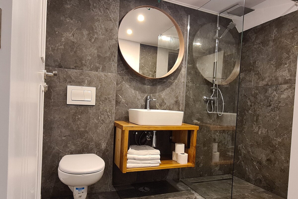 A modern bathroom with a toilet, sink, and shower.