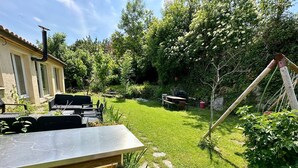 A backyard with a wooden table and chairs, a barbecue grill, and a hammock. - Large, comfortable villa in the Cévennes, mountains, lakes and rivers. Pets welcome! (concoules)