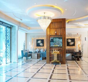 A spacious lobby with a chandelier, seating area, and artwork on the walls. - Palette Luxury Credi Hotel (Riyadh)