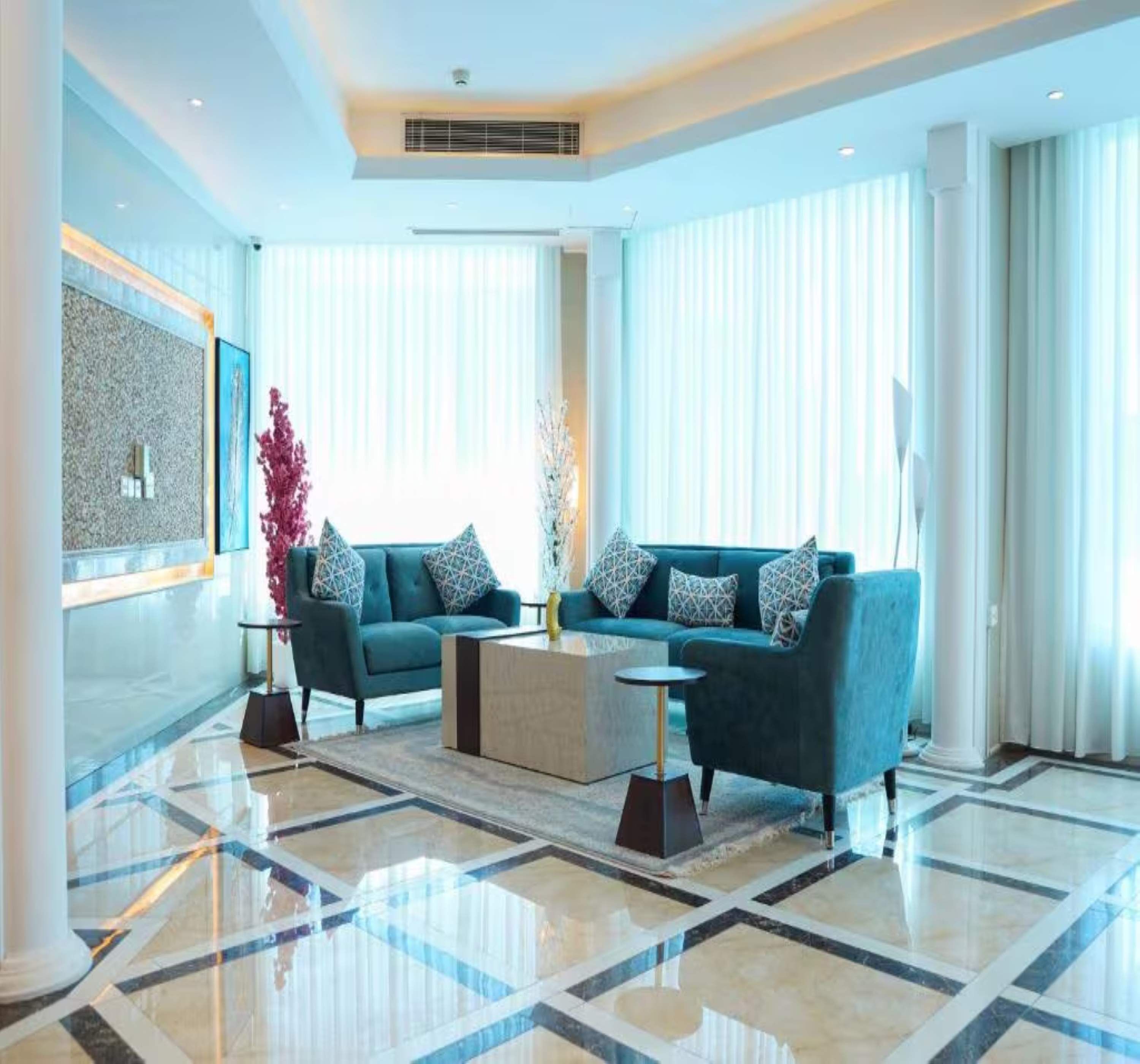 Una sala de estar moderna con un sofá azul, una mesa de centro y un jarrón decorativo.