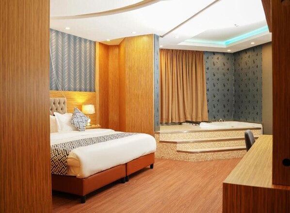 A modern hotel room with a large bed, a desk, and a separate bathroom area. - Palette Luxury Credi Hotel (Riyadh)