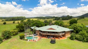 A large house with a pool, surrounded by lush greenery and hills. - The Old Sugar Mill Country Escape in Paradise (Bridges)