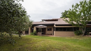 A two-story house with a patio and a covered outdoor seating area.