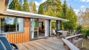 Ein modernes Haus mit Terrasse, großen Fenstern und einer Patio.