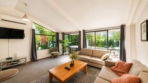 Ein modernes Wohnzimmer mit einer Couch, einem Couchtisch und einem Fernseher.