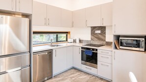 A modern kitchen with stainless steel appliances, a built-in oven, and a microwave.