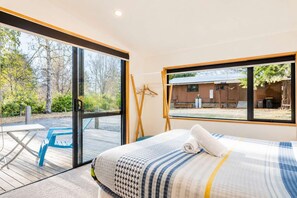 Una habitación con cama, una mesa y vistas al exterior.