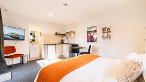 A hotel room with a bed, a desk, a chair, a small kitchenette, and a TV. - Polaris | Lake Tekapo | Near Church + Balcony (Lake Tekapo)