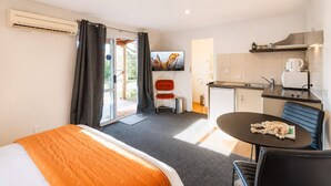 A hotel room with a bed, a dining table, a kitchenette, and a TV. - Polaris | Lake Tekapo | Near Church + Balcony (Lake Tekapo)