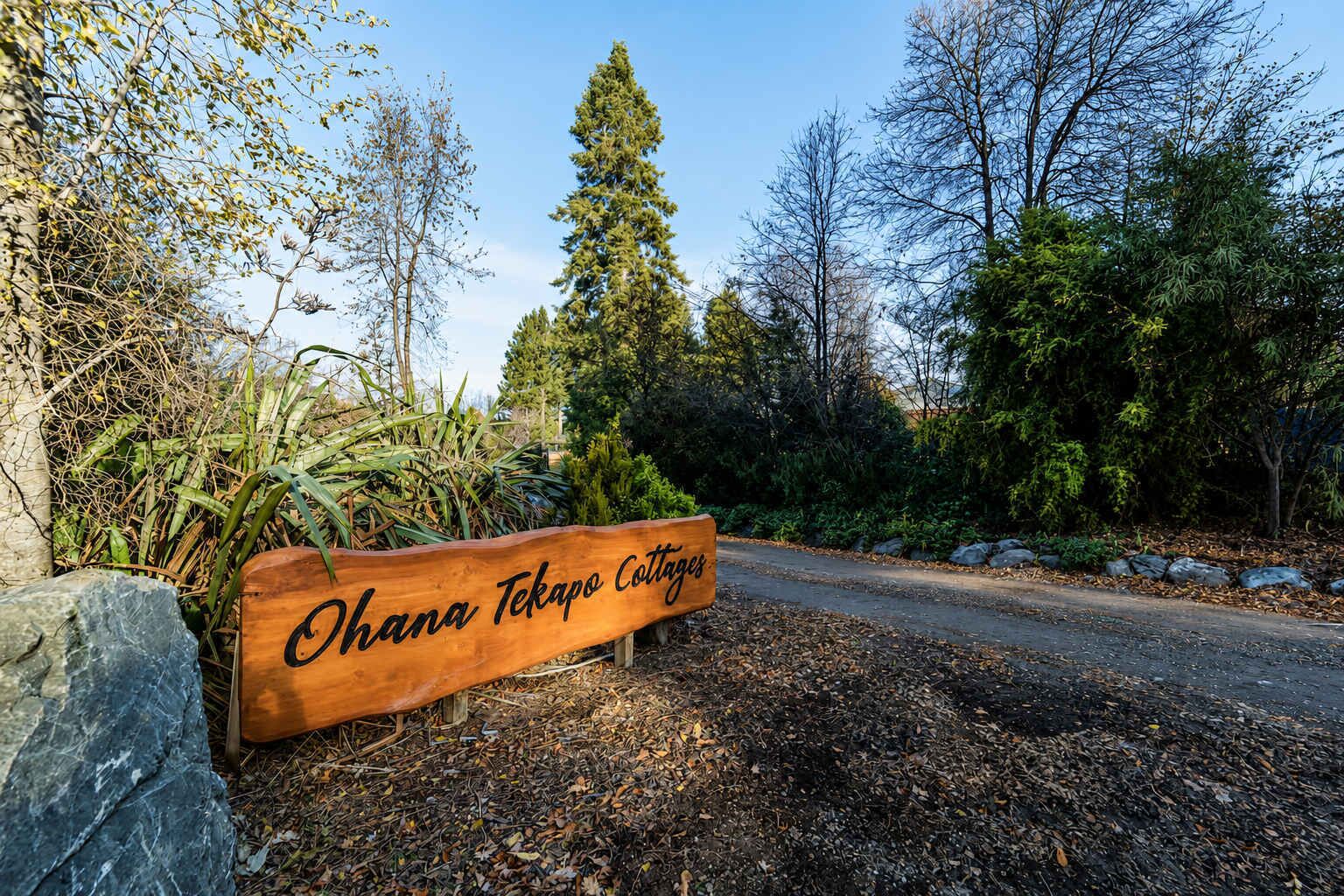 A wooden sign with the text 'Ohana Tekapo Cottages' indicating the name of the property.