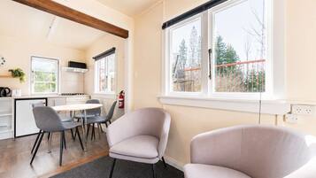 Una cocina moderna con comedor, una ventana con vistas a árboles y un extintor en la pared.