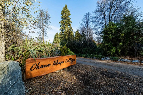 A wooden sign with the text 'Ohana Tekapo Cottages' indicating the name of the property.