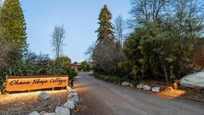 A sign for Ohana Tekapo Cottages with a gravel path leading to a building. - Little Dipper | 2BR | Near Lake + Church (Lake Tekapo)