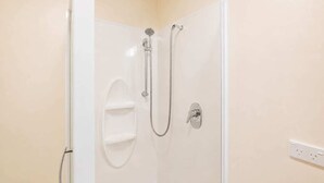A shower with a handheld showerhead and a wall-mounted faucet. - Little Dipper | 2BR | Near Lake + Church (Lake Tekapo)