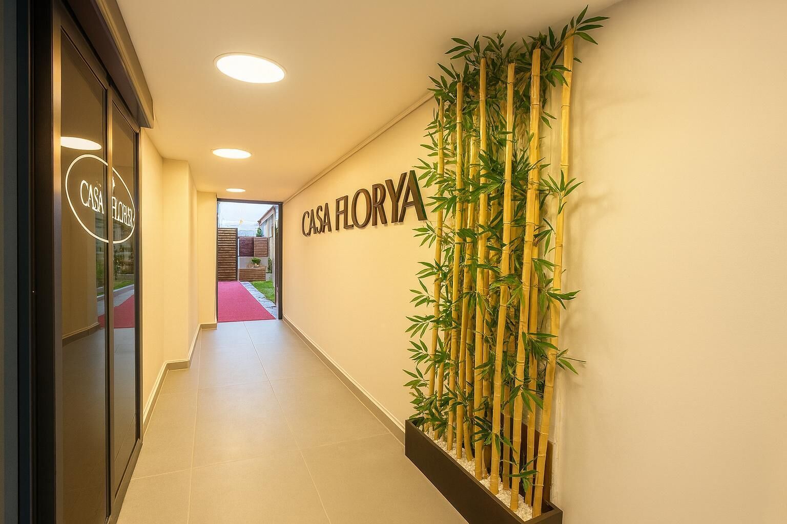 A hallway with a sign reading "CASA FLORYA" and a bamboo plant wall.