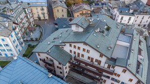 Vista aérea de un edificio con varios pisos, que combina espacios residenciales y comerciales.