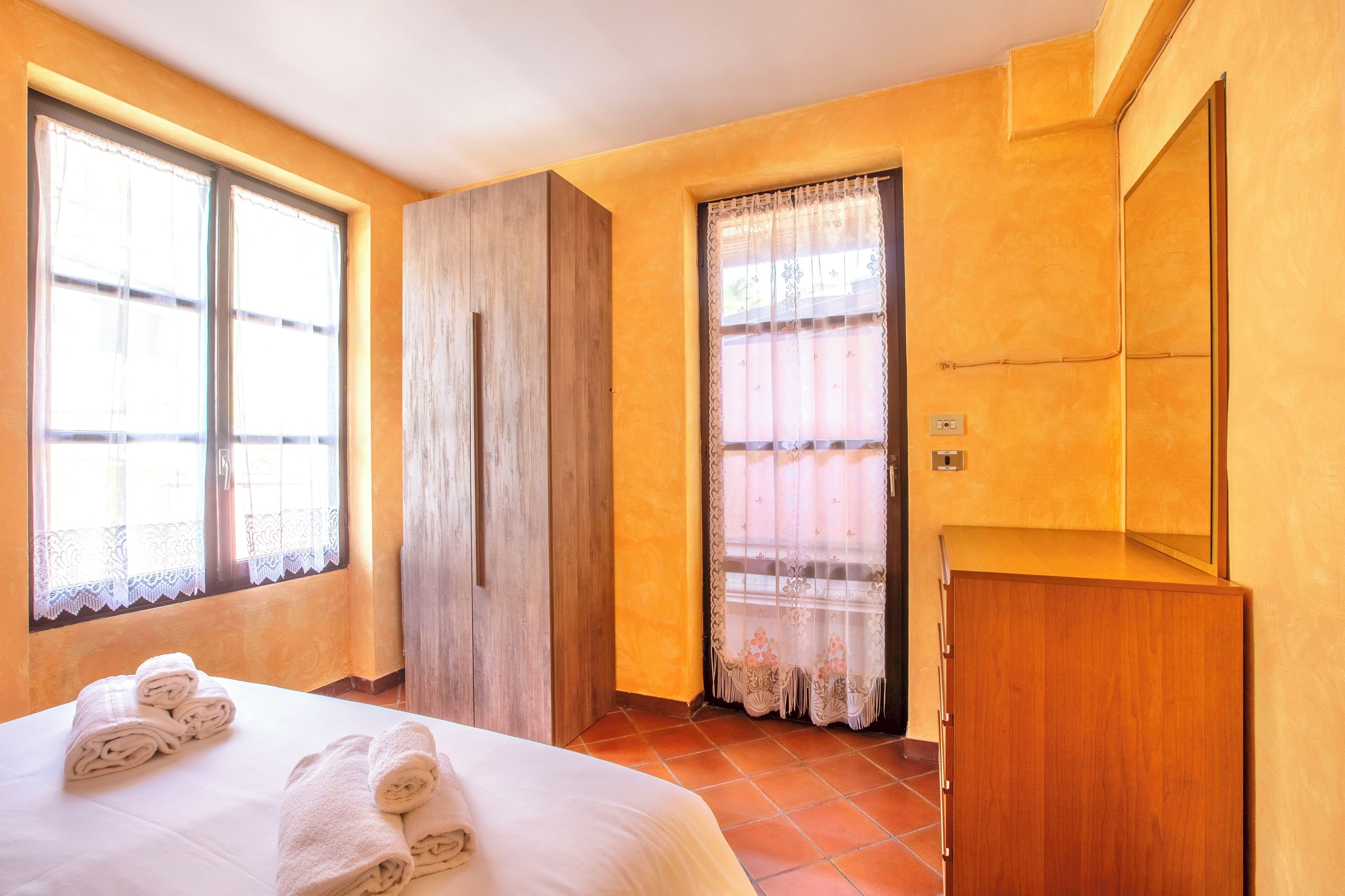 Una camera d'albergo con un letto, un armadio e uno specchio.