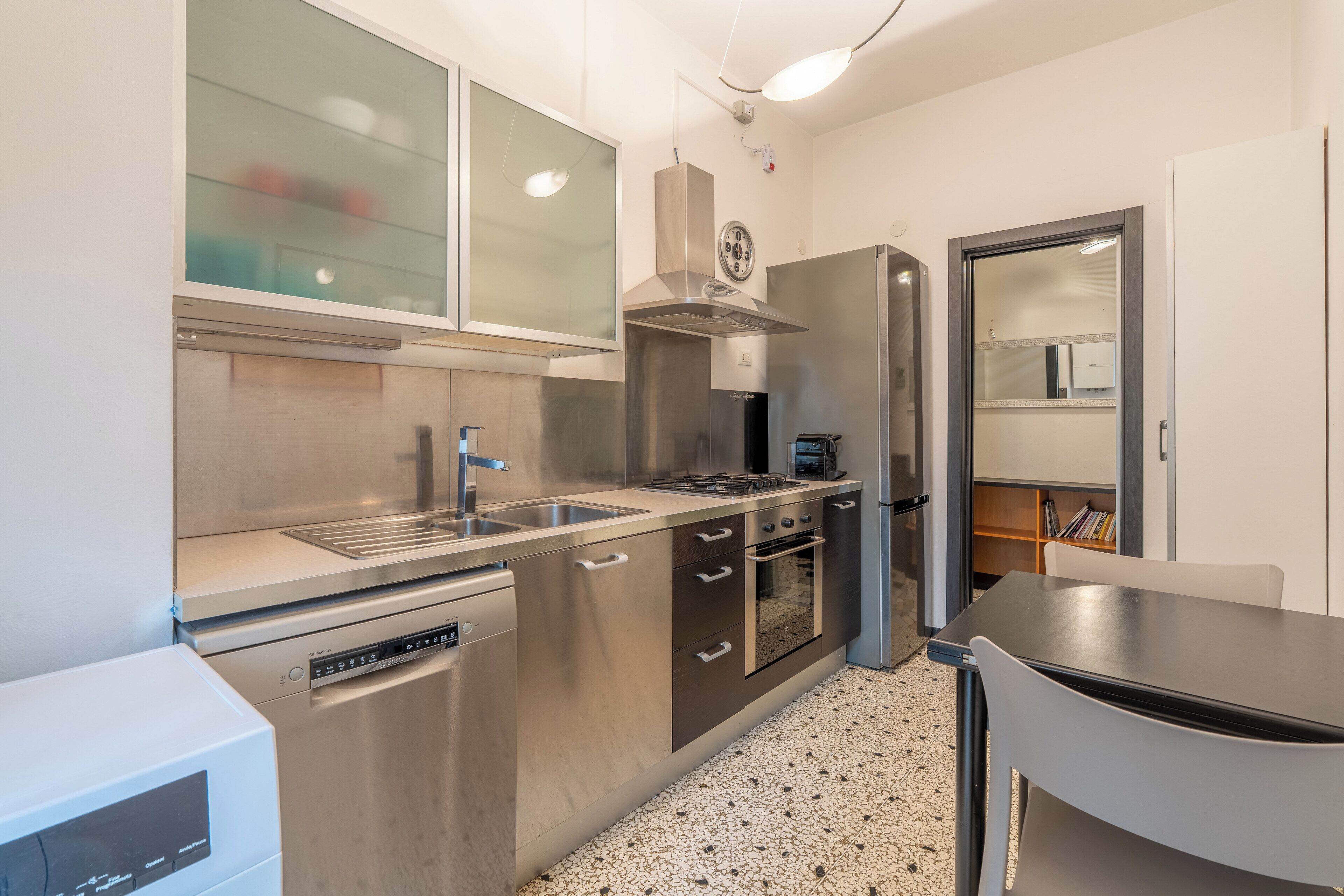 A modern kitchen with stainless steel appliances, a built-in oven, and a dishwasher.