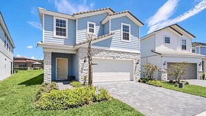 A two-story house with a stone facade, a garage, and a well-maintained lawn.