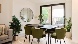 A dining area with a table, chairs, and a large window. - The South Wimbledon Escape - Lovely 3bdr With Balcony (London)