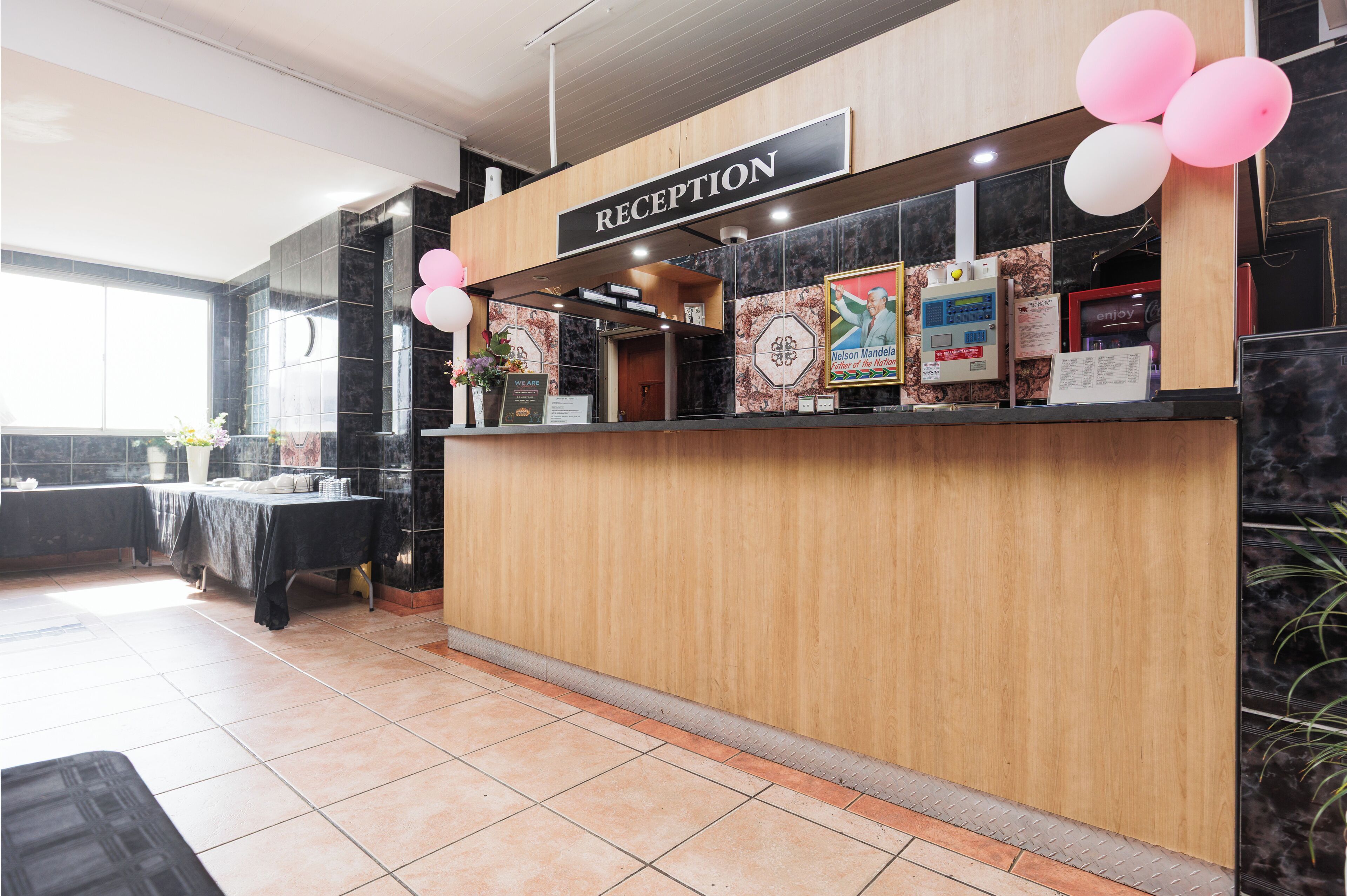 A reception area with a wooden counter, a sign labeled "RECEPTION," and a window providing natural light.
