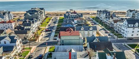 Une zone résidentielle côtière avec des maisons, une route et une plage en arrière-plan.