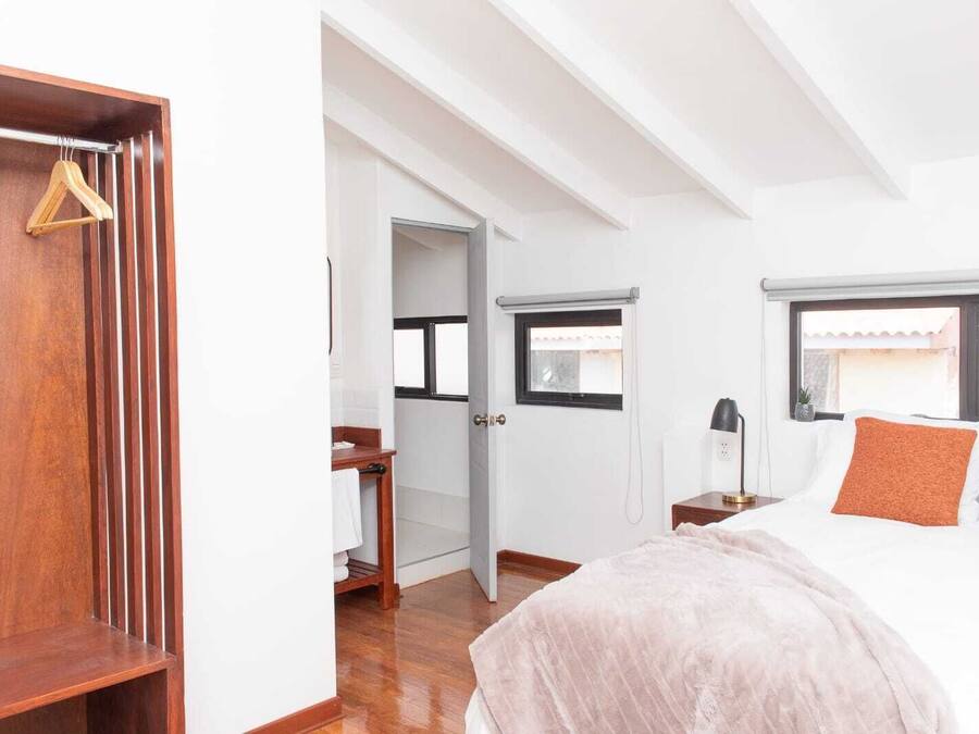 Un dormitorio con cama, mesita de noche y armario.