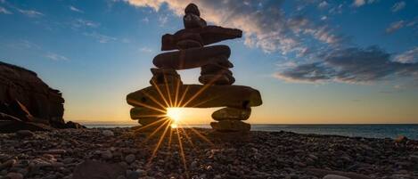 Una pila de piedras con el sol poniéndose al fondo.