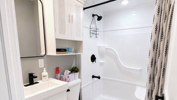 Un baño moderno con inodoro, lavabo y ducha.