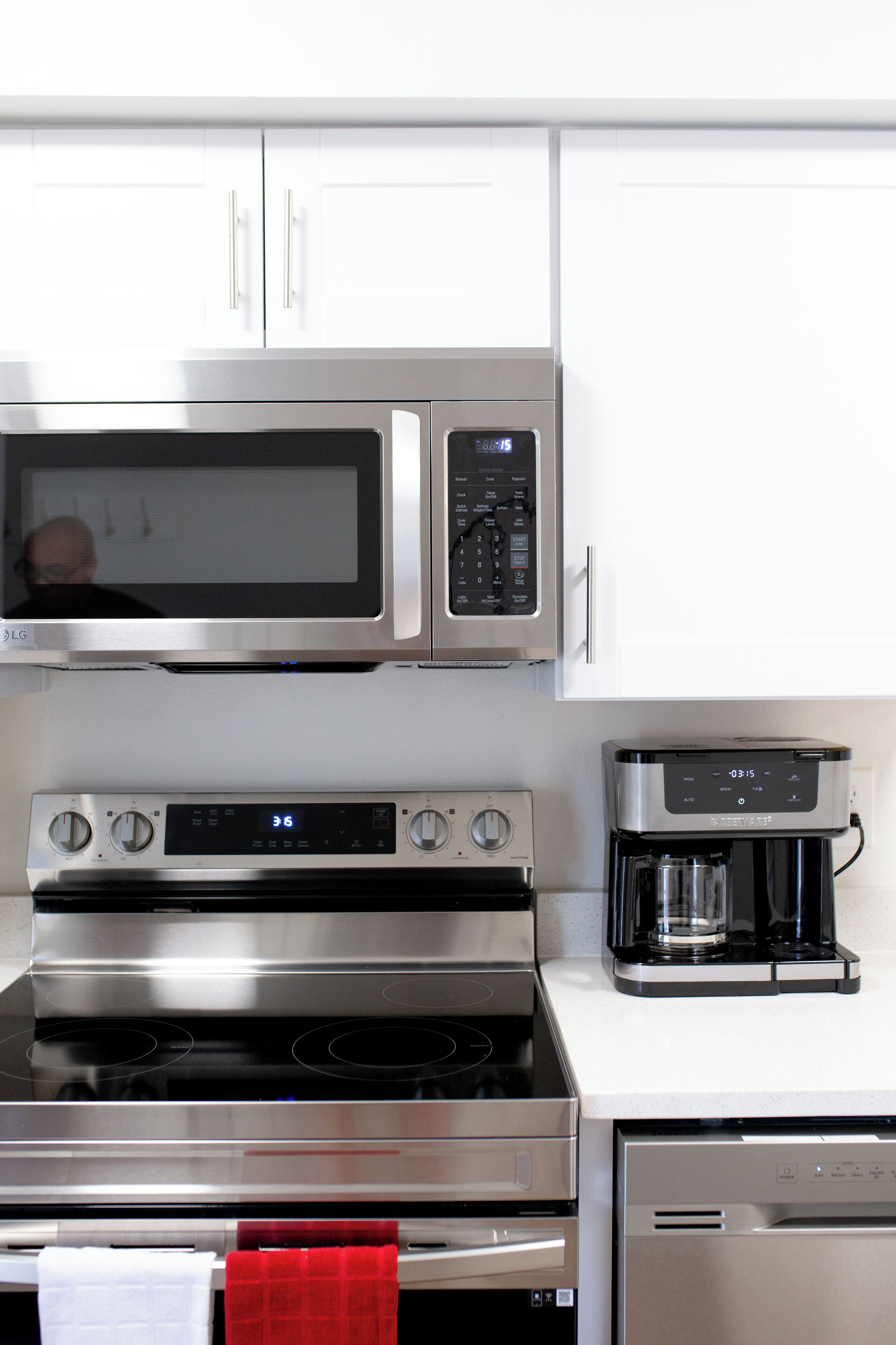 Una cocina con microondas, horno y cafetera.
