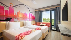 A hotel room with two beds, a balcony with a view, a desk, and a cityscape mural. - Ginger Udaipur Shastri Circle (Udaipur)