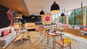 A modern interior with a dining area, seating, and a kitchen. - Ginger Udaipur Shastri Circle (Udaipur)