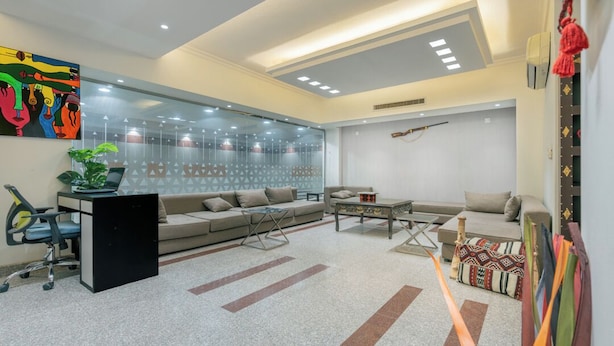 A modern living room with a sofa, coffee table, and a glass partition wall.