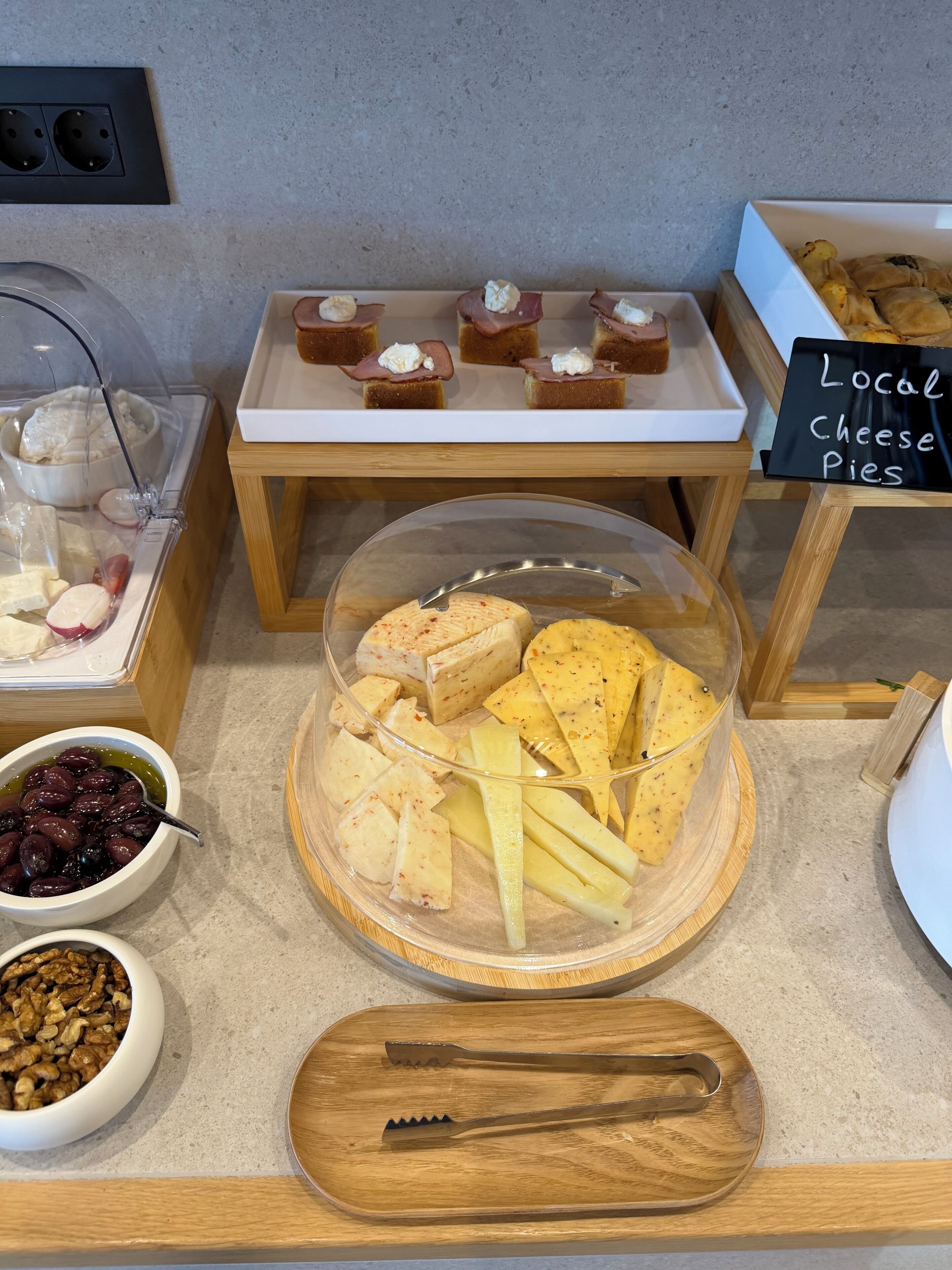 Una exhibición de alimentos con diversos quesos, frutas y pasteles.